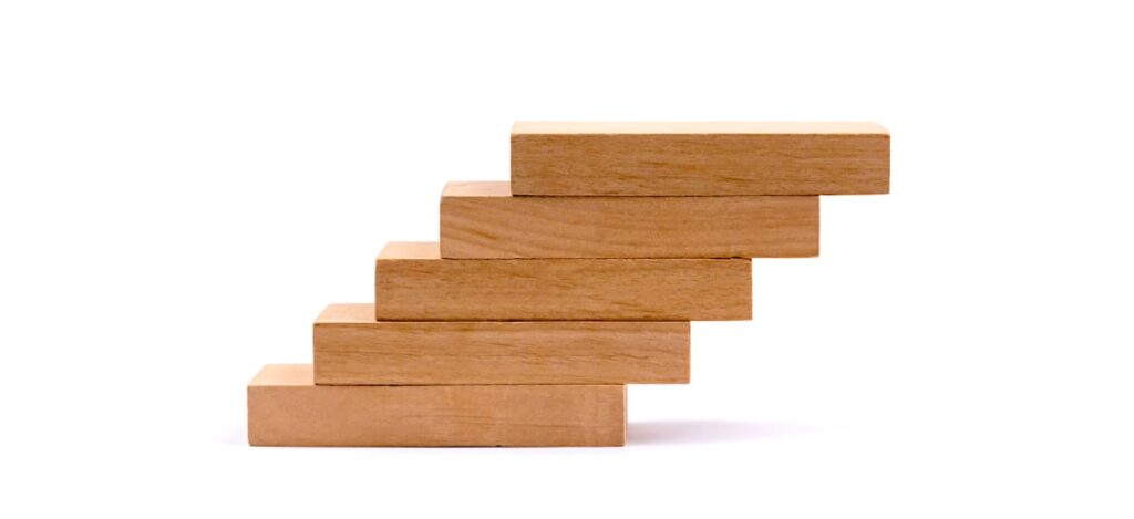 Ascending wooden block steps representing tiered business growth